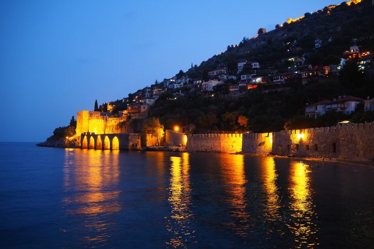 brown concrete building near body of water during night time